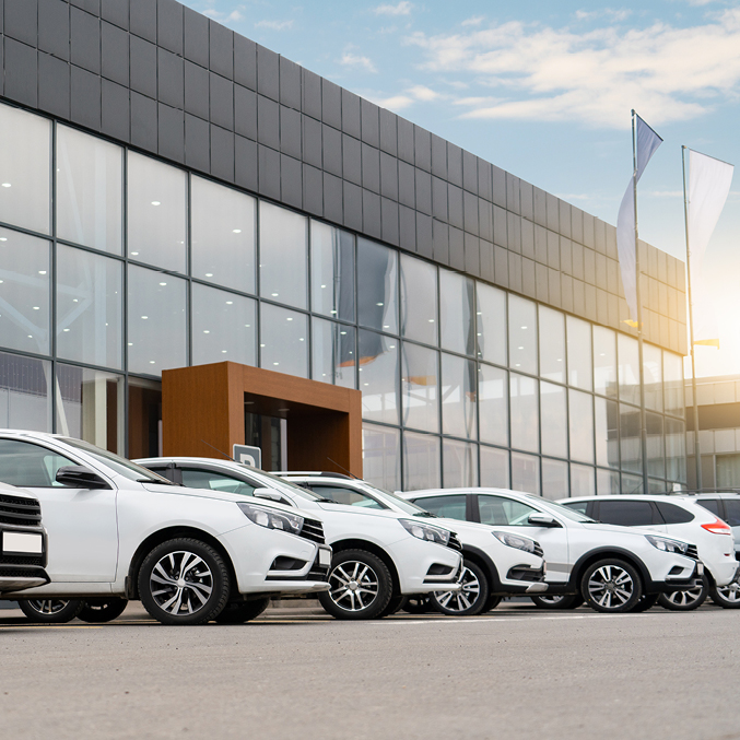 A line of white cars outside a dealership